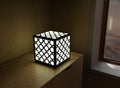 300mm metal cube lamp featuring a cross lattice cut-out pattern, white plexiglass panels, and a textured black finish.