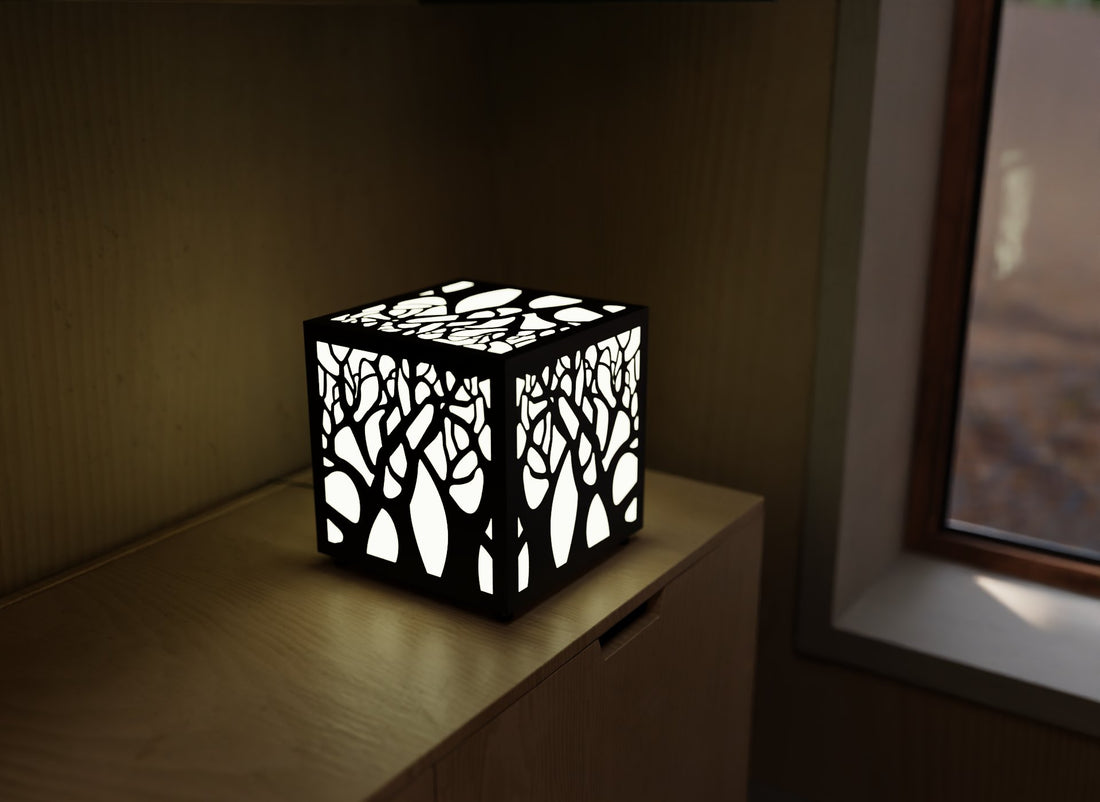 300mm metal cube lamp featuring a enchanted forest cut-out pattern, white plexiglass panels, and a textured black finish.