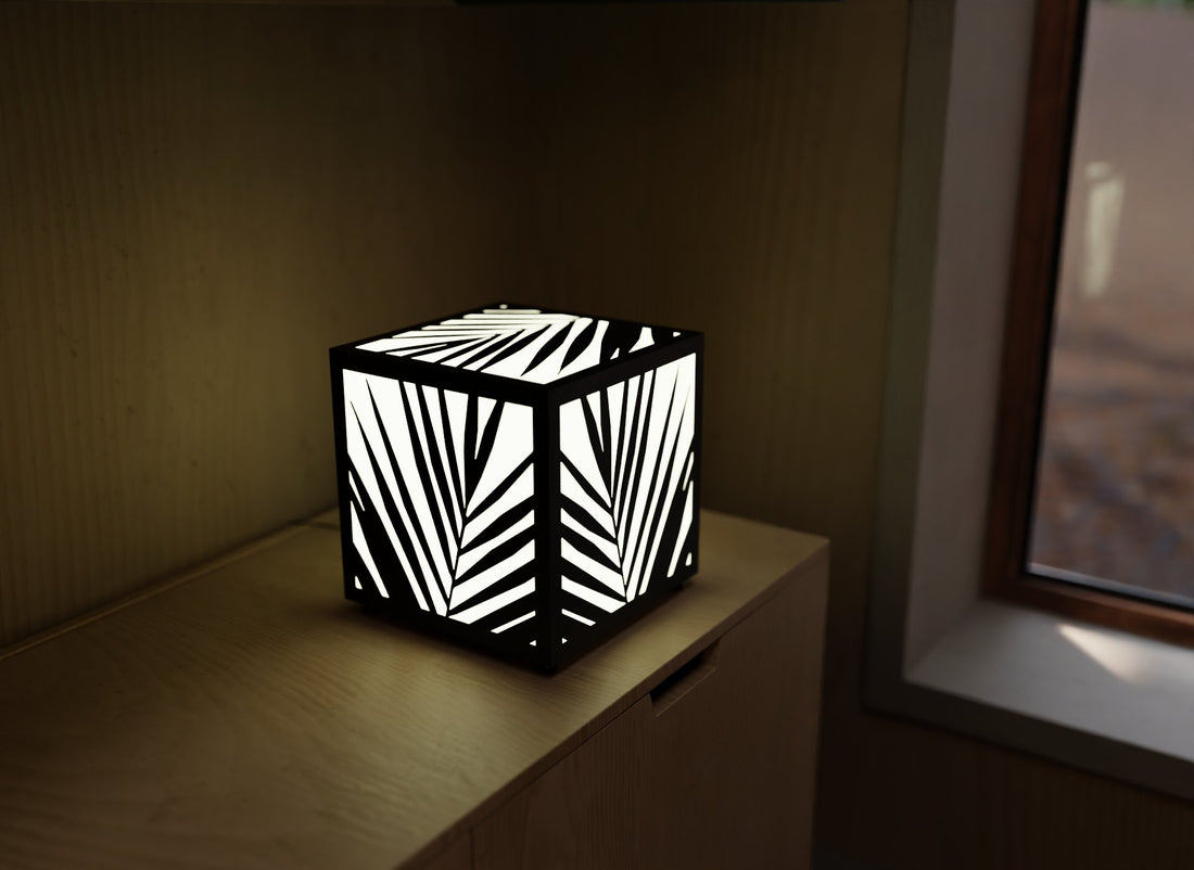 300mm metal cube lamp featuring a palm shadow grid cut-out pattern, white plexiglass panels, and a textured black finish.