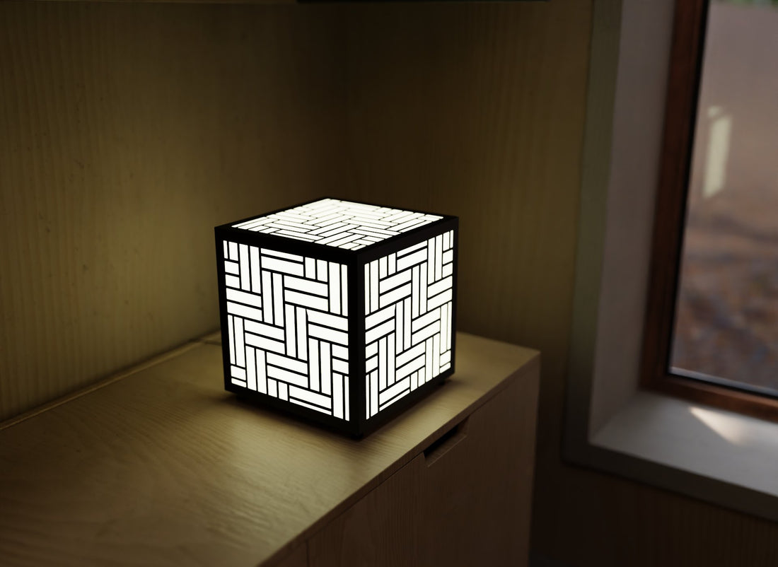 300mm metal cube lamp featuring a basket weave cut-out pattern, white plexiglass panels, and a textured black finish.
