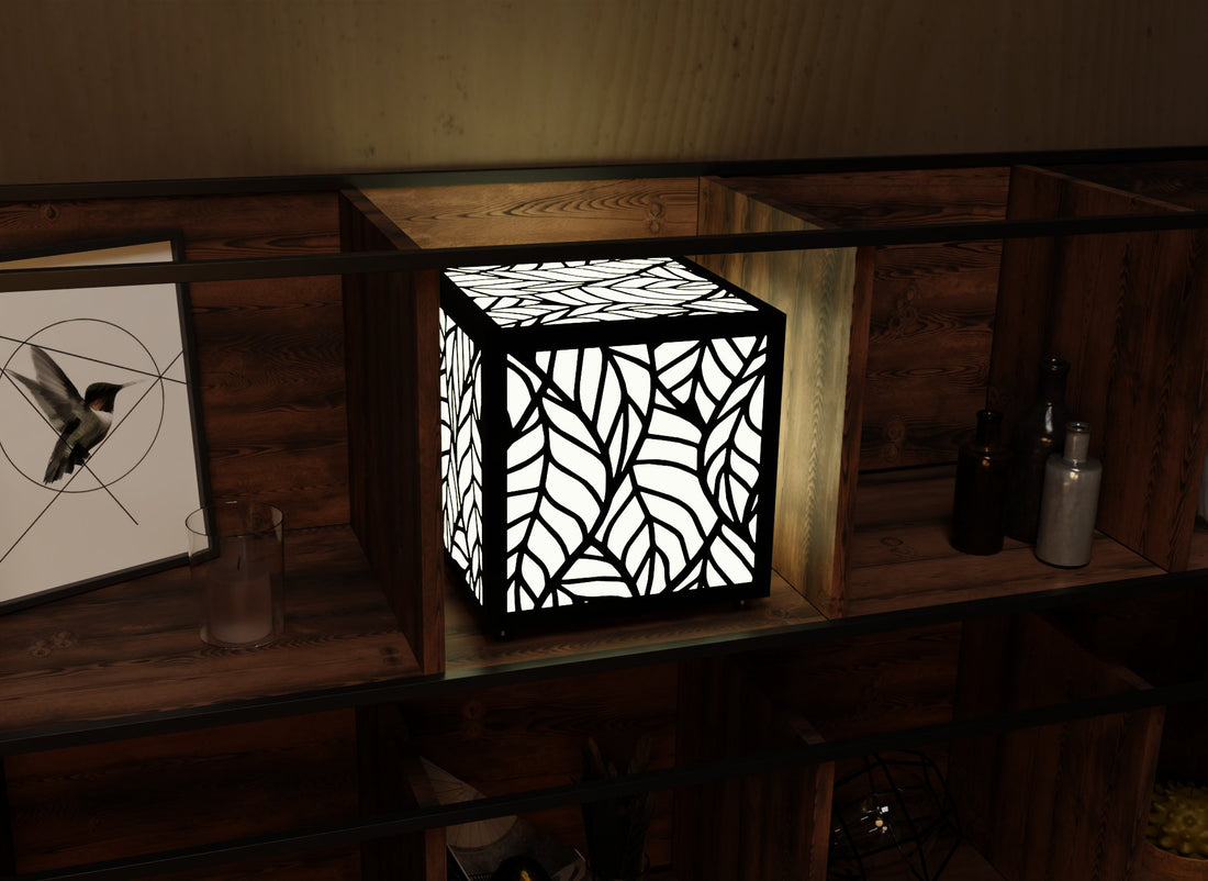 300mm metal cube lamp featuring a leafy cut-out pattern, white plexiglass panels, and a textured black finish.