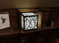 300mm metal cube lamp featuring a leafy cut-out pattern, white plexiglass panels, and a textured black finish.