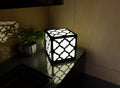 300mm metal cube lamp featuring a Moroccan trellis cut-out pattern, white plexiglass panels, and a textured black finish.