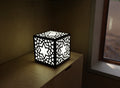 300mm metal cube lamp featuring a starburst cut-out pattern, white plexiglass panels, and a textured black finish.